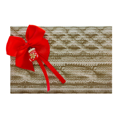 Pakowanie na prezent w papier ze wzorem sweterkowym, czerwoną kokardką i ozdobą świąteczną