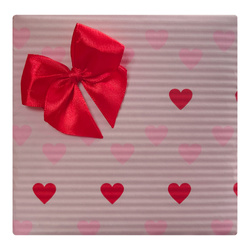 Pakowanie na prezent w różowy papier w serca z czerwoną kokardką
