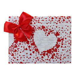 Pakowanie na prezent w biały papier w serduszka z czerwoną kokardką